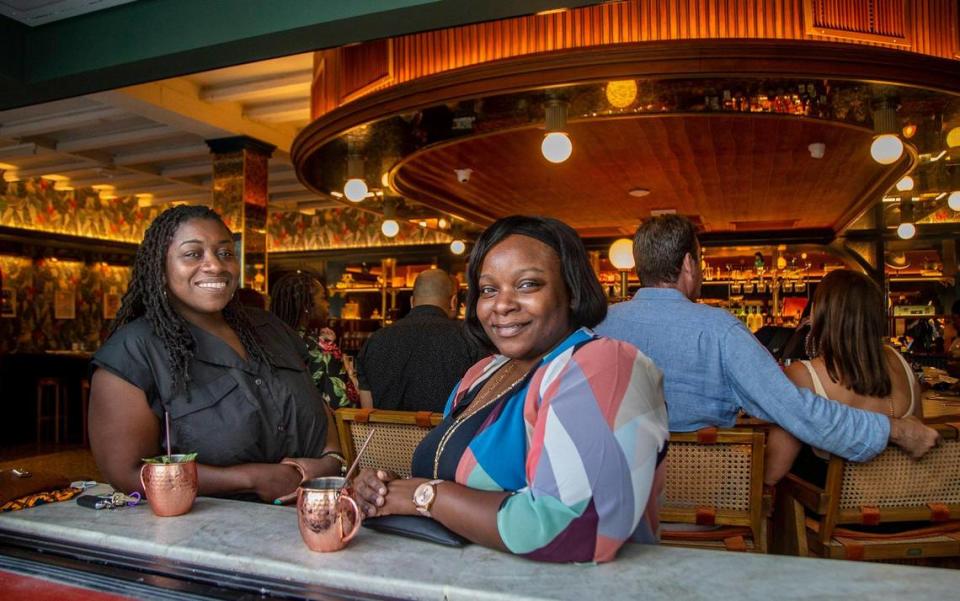 Miami residents Maya Gibson (left) and Rose Daniels enjoy drinks during Happy Hour at the Red Rooster restaurant in the heart of Overtown in April.