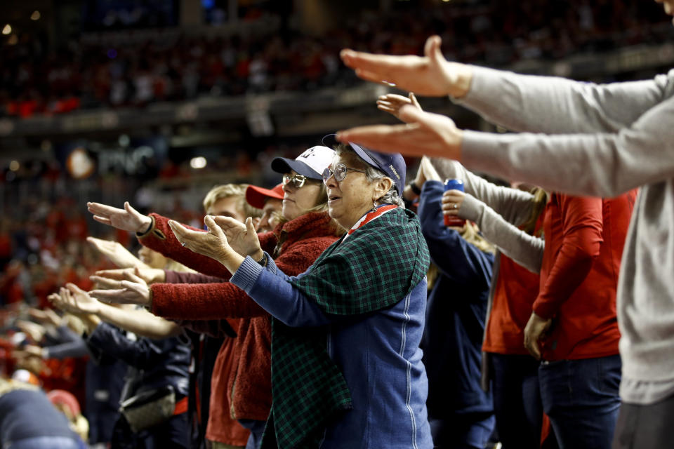 FILE - In this Oct. 25, 2019, file photo, fans gesture the baby shark as Washington Nationals' Gerardo Parra bats during the sixth inning of Game 3 of the baseball World Series against the Houston Astros, in Washington. Creators of the viral video “Baby Shark,” whose “doo doo doo” song was played at the World Series in October, are developing a version in Navajo. (AP Photo/Patrick Semansky, File)