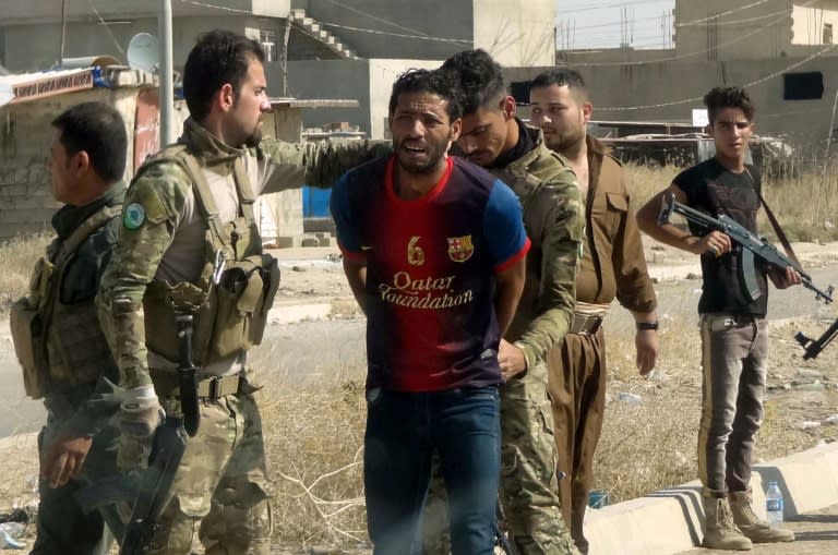 Iraqi Kurdish security forces detain a suspected member of IS group as they patrol the eastern suburbs of Kirkuk on October 22, 2016