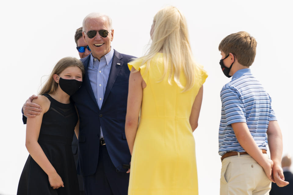 President Joe Biden is greeted by Kentucky Gov. Andy Beshear, just behind Biden, his wife Britainy Beshear, second from right, and their children Lila Beshear, 11, left, and Will Beshear, 12, right, as he arrives at Cincinnati/Northern Kentucky International Airport in Hebron, Ky., Wednesday, July 21, 2021, to travel to Cincinnati for a town hall and to tour an electrical training center. (AP Photo/Andrew Harnik)