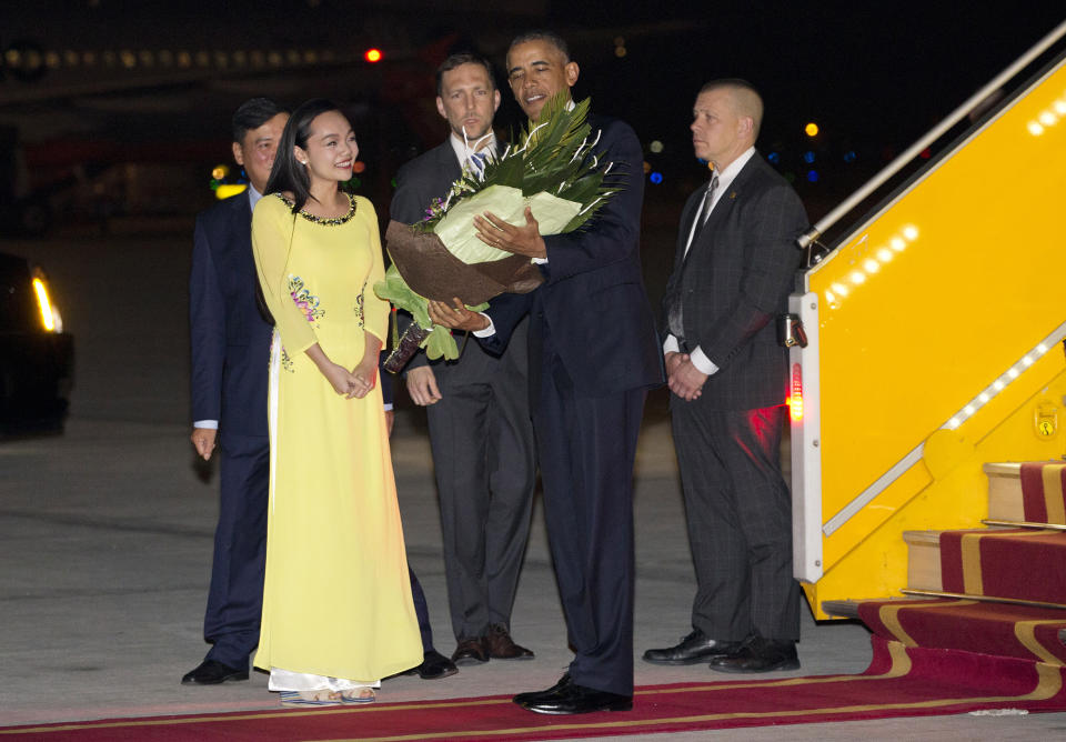 <p>U.S. President Barack Obama is given flowers by Linh Tran, the ceremonial flower girl, as he arrives on Air Force One at Noi Bai International Airport in Hanoi, Vietnam, Sunday, May 22, 2016. The president is on a weeklong trip to Asia as part of his effort to pay more attention to the region and boost economic and security cooperation. (AP Photo/Carolyn Kaster) </p>