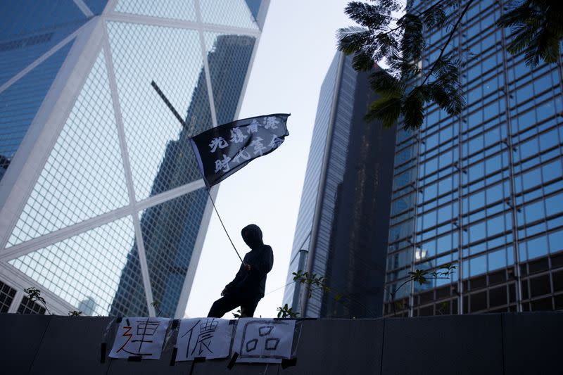 A protester waves a flag reading "Reclaim Hong Kong, Revolution of our Time" during an anti-government protest in the Central district of Hong Kong