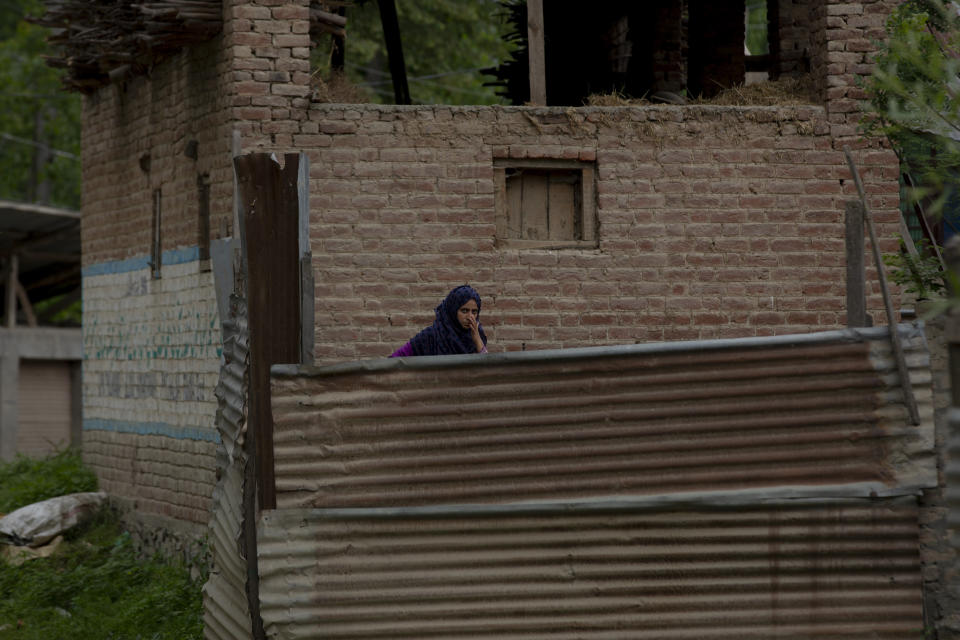 A Kashmiri Muslim woman watches as police and army soldiers launch an operation in Awantipora area, south of Srinagar, Indian controlled Kashmir, Wednesday, May 6, 2020. Government forces killed a top rebel commander and his aide in Indian-controlled Kashmir on Wednesday and shut down cellphone and mobile internet services during subsequent anti-India protests, officials, and residents said. (AP Photo/ Dar Yasin)