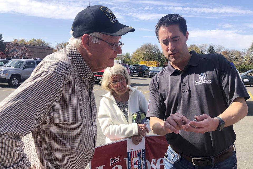 Ruth and Boyd Boone speak with Ohio’s Republican Secretary of State Frank LaRose, in a Kroger’s parking lot, Sunday, Oct. 23, 2022, in Groveport, Ohio. (AP Photo/Jill Colvin)