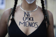 A woman with the words "Not one less" written on her chest in Spanish joins a march to commemorate International Women's Day and protest against gender violence, in Mexico City, Monday, March 8, 2021. (AP Photo/Rebecca Blackwell)