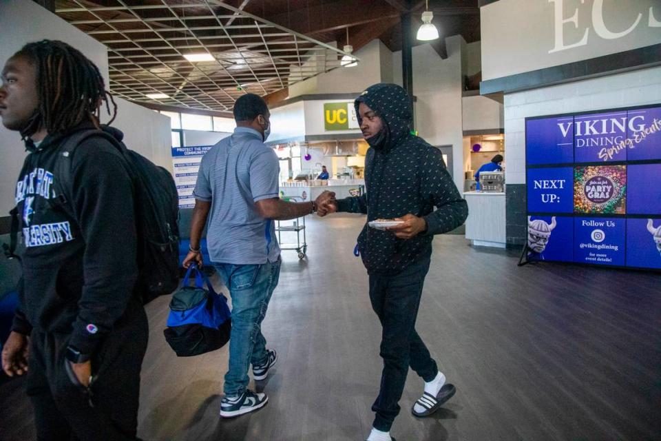 Juanya’ Majette, a senior linebacker at Elizabeth City State University, bumps fist with friends at Elizabeth City State’s Bedell Hall cafeteria Tuesday, March 1, 2022.