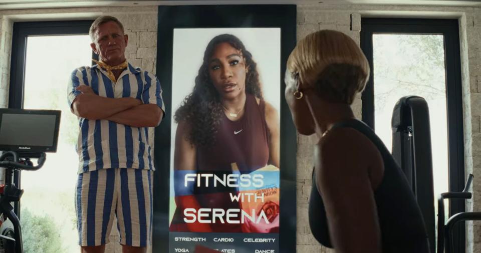 Daniel Craig and Janelle Monáe standing between a video screen of Serena Williams