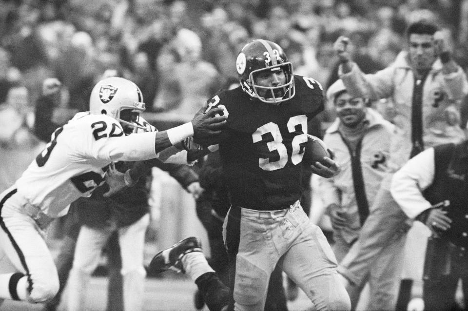 FILE - Pittsburgh Steelers' Franco Harris (32) eludes a tackle by Oakland Raiders' Jimmy Warren as he runs 42-yards for a touchdown after catching a deflected pass during an AFC Divisional NFL football playoff game in Pittsburgh on Dec. 23, 1972. Harris died on Wednesday morning, Dec. 21, 2022, at age 72, just two days before the 50th anniversary of The Immaculate Reception. (AP Photo/Harry Cabluck, File)
