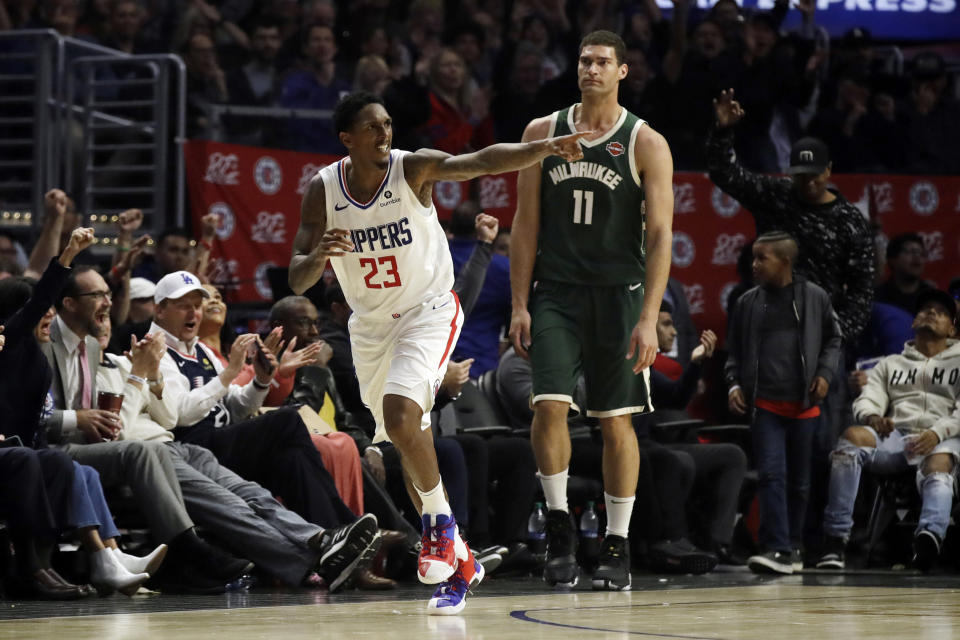 Los Angeles Clippers' Lou Williams (23) points after making 3-point basket, in front of Milwaukee Bucks' Brook Lopez (11) during the second half of an NBA basketball game Wednesday, Nov. 6, 2019, in Los Angeles. (AP Photo/Marcio Jose Sanchez)
