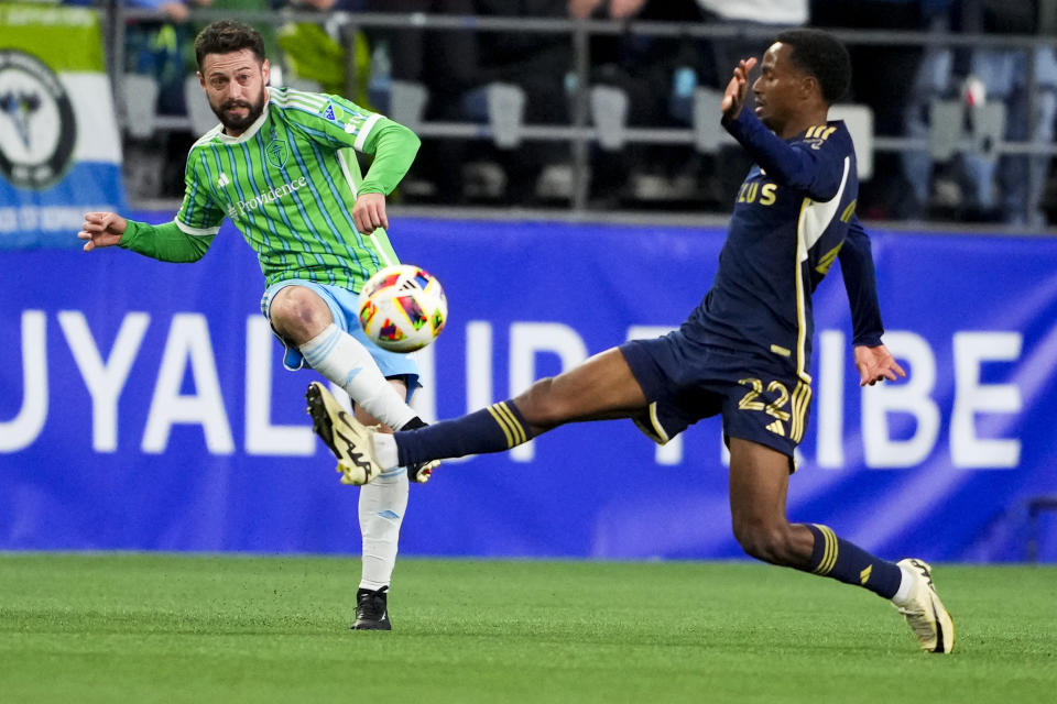 Seattle Sounders midfielder João Paulo makes a pass against Vancouver Whitecaps forward Ali Ahmed (22) during the first half of an MLS soccer match Saturday, April 20, 2024, in Seattle. (AP Photo/Lindsey Wasson)