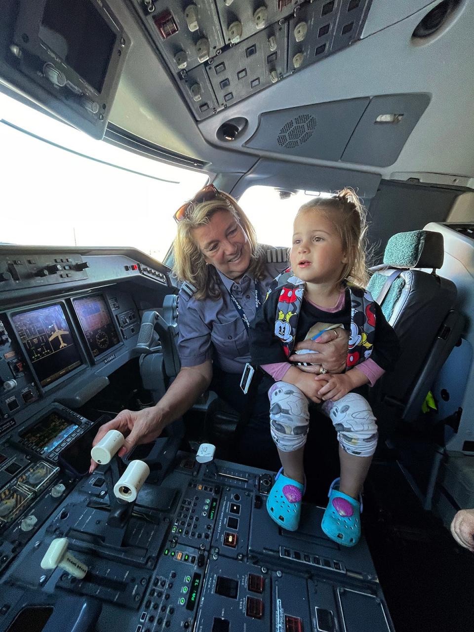 Assitant Chief Pilot, Margrit Fahan of Hartford, Conn. shows Kennedy Walker, 4, of Eagle Mountain, Utah, the cockpit during a mock trip. Fahan has been flying since 1975. Breeze Airways hosted an exercise for people with autism, ages 3-20, to experience the process of airplane procedures to make future travel easier.