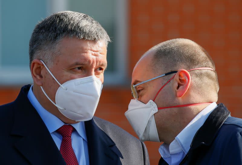 Ukrainian Interior Minister Avakov and Health Minister Stepanov speak near a plane as medical personnel depart for coronavirus-hit Italy at an airport in Kiev