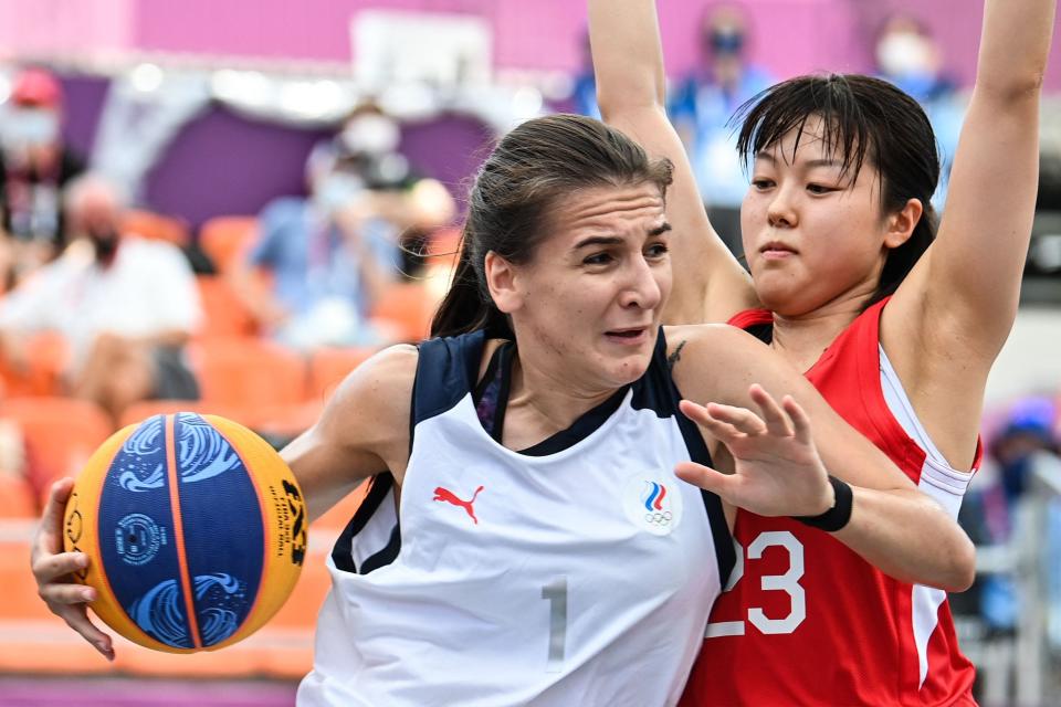 Russia's Yulia Kozik (L) and Japan's Mai Yamamoto fight for the ball during the women's first round 3x3 basketball match.