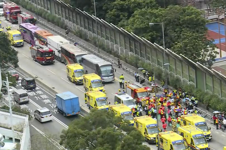 In this image taken from a video footage run by TVB, rescue workers attend to the aftermath after four passenger buses and a truck collided near a Hong Kong road tunnel Friday, March 24, 2023. Dozens were injured, including children. Most of the injuries were minor. (TVB via AP)