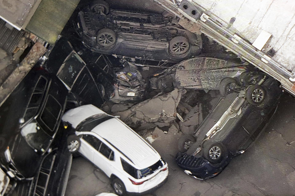 Cars are seen at the partial collapse of a parking garage in the Financial District of New York, Wednesday, April 19, 2023, in New York. The parking garage collapsed Tuesday in lower Manhattan’s Financial District, killing one worker, injuring five and crushing cars as concrete floors fell on top of each other like a stack of pancakes, officials said. (Tom Kaminski/WCBS 880 News via AP)