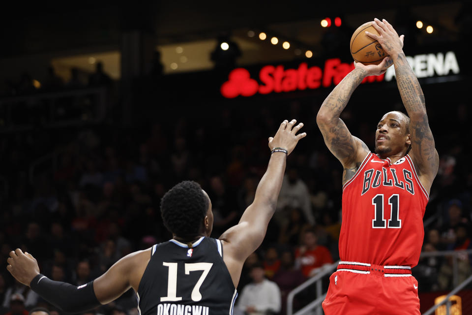 Chicago Bulls forward DeMar DeRozan (11) , right, shoots over Atlanta Hawks forward Onyeka Okongwu (17), left, during the first half of an NBA basketball game on Monday, Feb. 12, 2024, in Atlanta. (AP Photo/Alex Slitz)