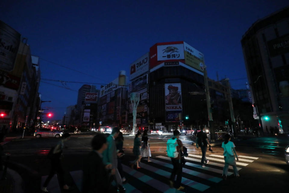 <p>Quake-affected residents walk during an electrical blackout at the shopping district in Sapporo on Sept. 6, 2018, after an earthquake hit the northern Japanese island of Hokkaido. Rescuers scrambled through mud for survivors after a powerful earthquake sent hillsides crashing down onto homes in Japan, killing at least nine people and leaving dozens of people missing. (Photo from Jiji Press/AFP/Getty Images) </p>