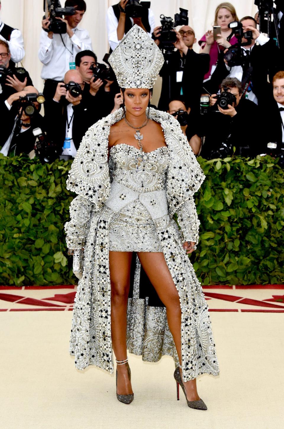 Rihanna attends the 2018 Met Gala wearing a bedazzled papal look, complete with a pope hat.