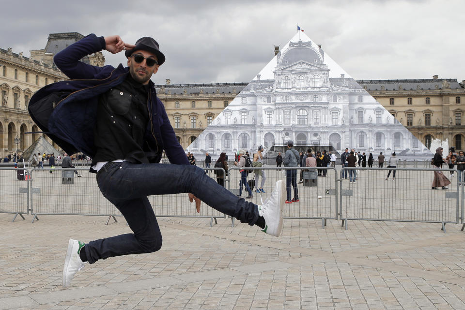 <p>Street artist JR poses in front the Louvre Pyramid in Paris on May 24, 2016. For his latest project, he is creating an eye-tricking installation that makes it seem as if the huge glass pyramid has disappeared. (Francois Mori/AP) </p>