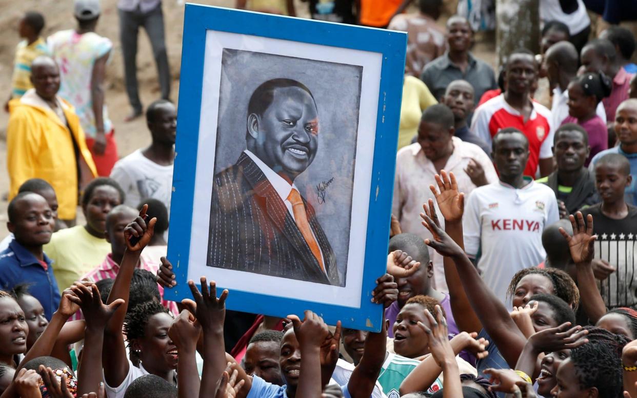 Supporters of opposition leader Raila Odinga hold his picture during a rally in the Mathare slum in Nairobi - REUTERS