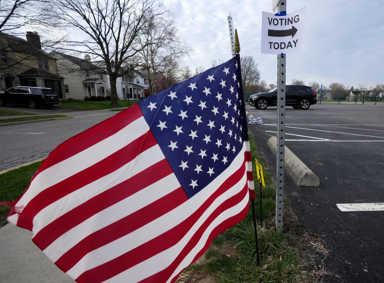 An American flag whips Tuesday on a windy Primary Election Day morning outside of Montrose Elementary school in Bexley.
