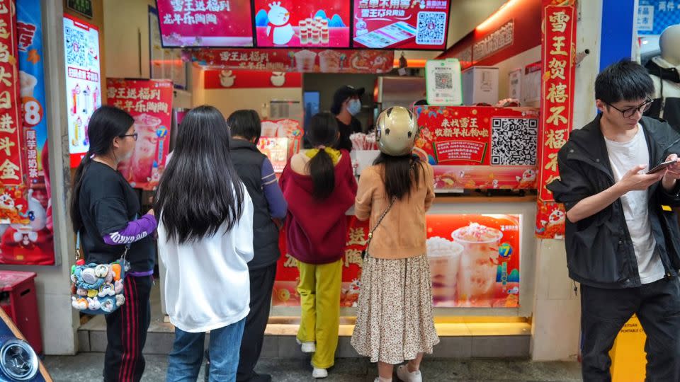 Shoppers wait in line to get beverages from Mixue Bingcheng, a purveyor of value priced bubble tea, in Shenzhen. - Justin Robertson/CNN