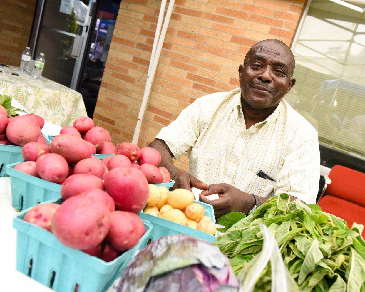 Burundi refugee Cubwa Rajabo with his stall of assorted vegetables in 2015 during the Global Greens Farmers Market.