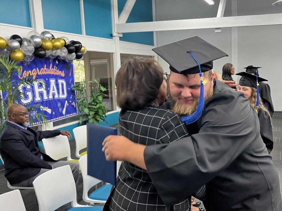 Marion County Acceleration Academies graduate Dylan Dotten shares a congratulatory hug with Valtena Brown, regional vice president of Acceleration Academies, during the commencement ceremony at the school on April 11. Twenty-six high school diplomas and one honorary diploma were conferred at the ceremony.