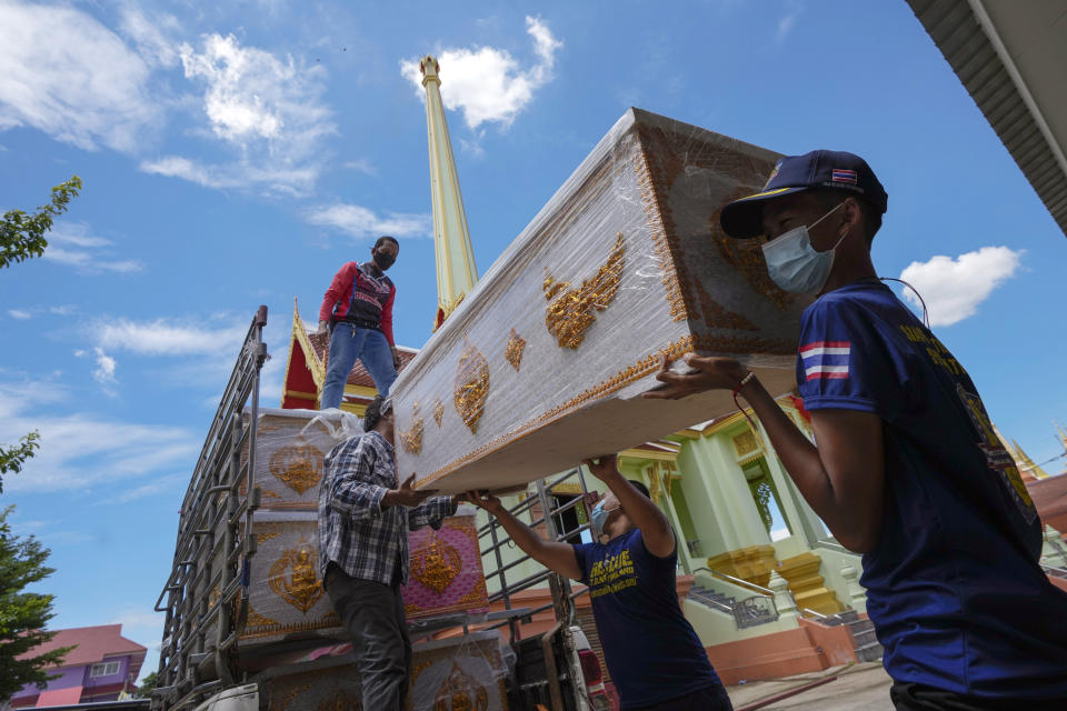 People donate an empty coffin for the Wat Ratprakongtham temple Nonthaburi Province, Thailand, Monday, July 12, 2021. Wat Ratprakongtham temple offering free funeral service for people dying from COVID-19 says it is struggling to keep up with 24-hour cremation, and is adding another crematorium as Thailand sees a growing number of cases and deaths in a coronavirus surge that began in early April. (AP Photo/Sakchai Lalit)