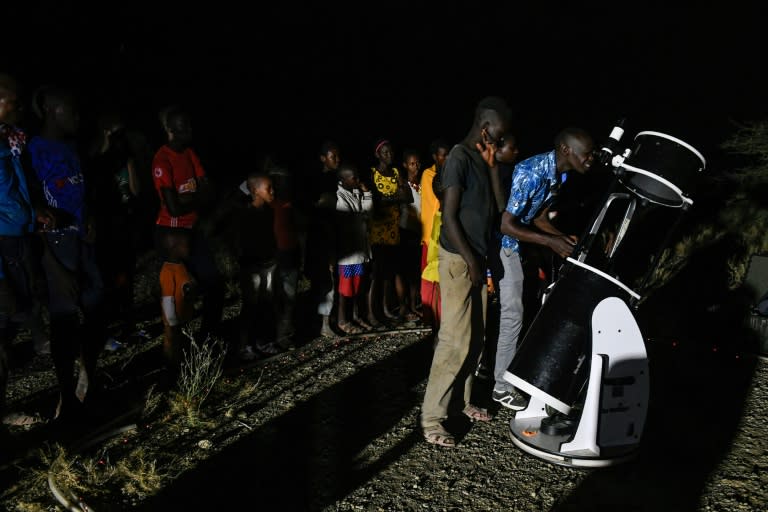 Young people watched the eclipse through a telescope beside Lake Magadi in Kenya