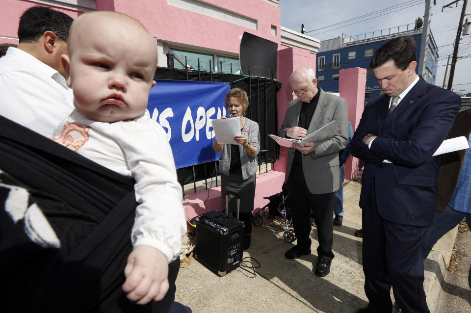 This photo taken March 5, 2014 shows seven-month old Abigail Dalton of Ridgeland, seeming to be listening as state Mississippi Sen. Chris McDaniel, R-Ellisville, right, as he prays with fellow abortion opponents, Laura Duran of Pro-Life Mississippi, left, Rev. Mike O'Brien, pastor of St. Richard Catholic Church in Jackson, center, outside the Jackson Women's Health Organization clinic in Jackson, Miss., during the first day of a 40-day pro-life mobilization outside the only facility in the state that still performs abortions. Thad Cochran is engaged in his toughest campaign in a generation. The former Appropriations Committee chairman faces a June 3 primary challenge from a two-term state lawmaker. Chris McDaniel riles up tea party voters by denouncing big federal spending and portraying the 76-year-old incumbent as a Washington insider who’s lost touch with folks back home. (AP Photo/Rogelio V. Solis)