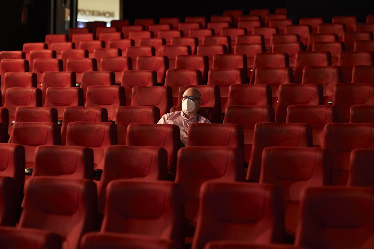 A man wearing a face mask waits for the beginning of the film in the Capitol cinema, opened at 20% capacity, on June 12, 2020 in Madrid, Spain.