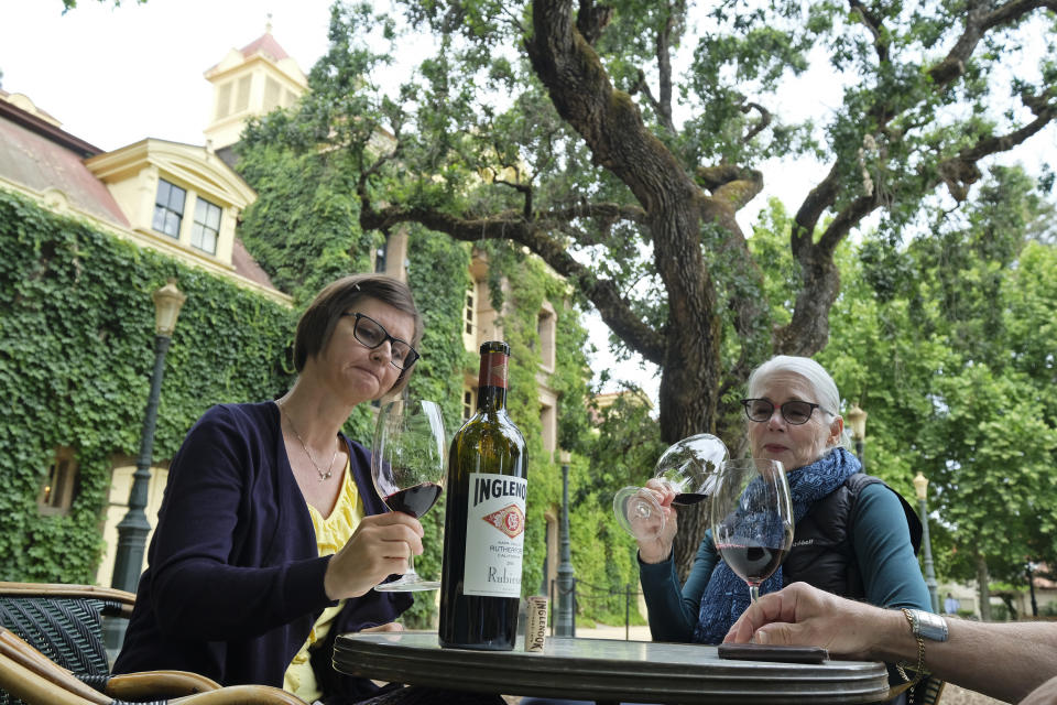 Shana Ayers, left, of Kansas City, Mo., Susan Goodwin, of Fresno, Calif., taste the 2016 Rubicon at the Inglenook winery Friday, June 12, 2020, in Rutherford, Calif. California wineries started uncorking their bottles and welcoming people back to their tasting rooms Friday as the state's $145 billion tourism industry gears up with hotels, zoos, museums and aquariums also allowed to reopen. The historic winery, which dates to 1879, reopened Friday to wine club members after being closed since mid March because of the coronavirus threat and will be open to the public on June 25. (AP Photo/Eric Risberg)
