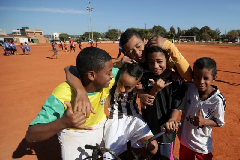 Children smile while posing for a photo after playing soccer in the neighborhood of Estrutural in Brasilia