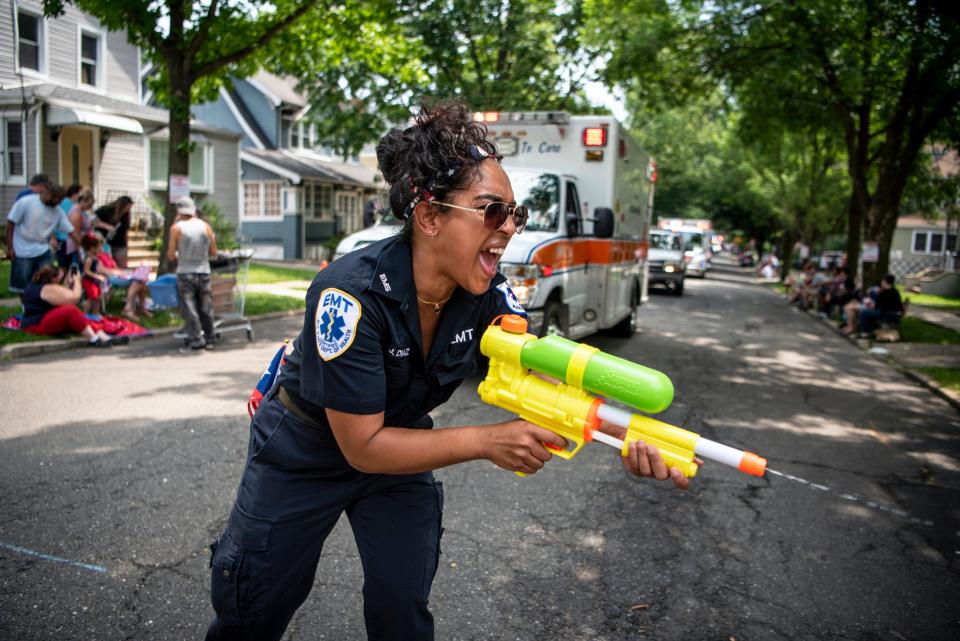 A volunteer Ridgefield EMT squirts her water gun into the crowds during the 127th Ridgefield Park Fourth of July parade on Monday, July 5, 2021. 