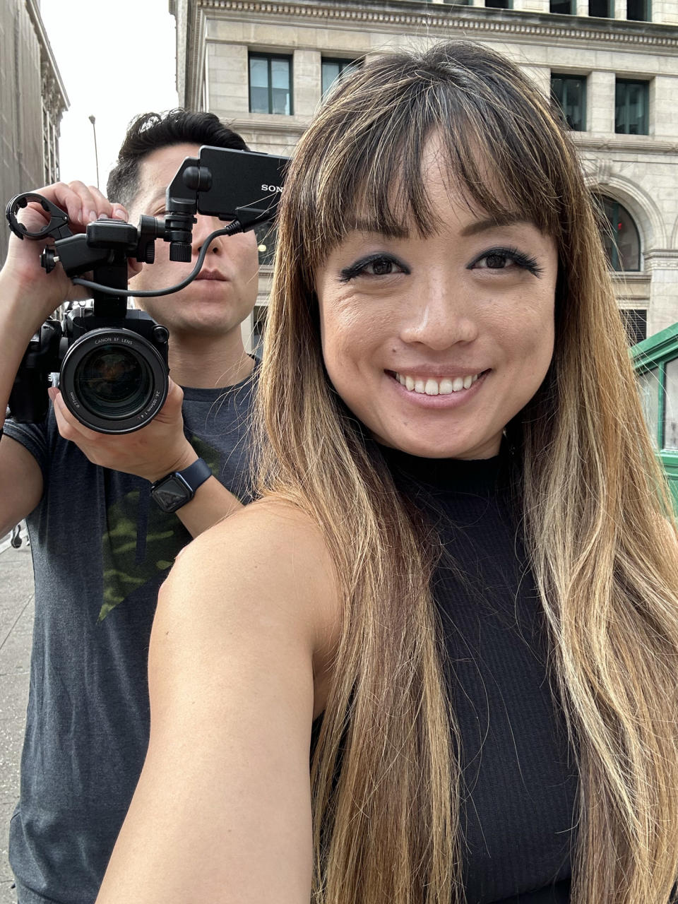 <p>A photo from the iPhone 14 Pro's front camera of a smiling woman and a man holding up a video camera.</p>
