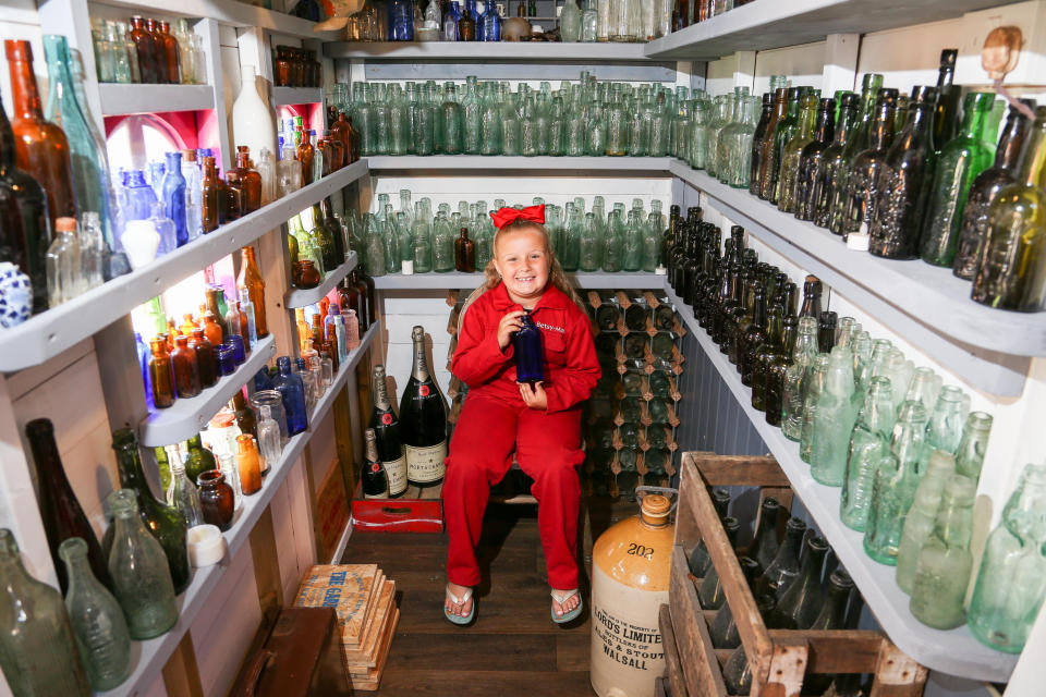 A seven-year-old schoolgirl is raking in hundreds of pounds by selling antique bottles from a little shop in her back garden - after digging them up from old landfill sites. Betsy-Mae Lloyd has been coining it in after launching her own business at her parents' home while still attending primary school. The young entrepreneur flogs old bottles, jars and teapots - dating back to between the 1870s and 1930 - which she finds on historic landfill sites in the West Midlands. After taking them home and cleaning them up herself, she then stores them in a Victorian-style play shed, built by dad Jason, before listing them for sale on Facebook. 