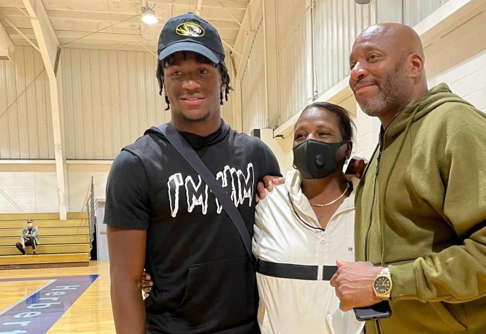 Newly committed to the Mizzou Tigers (check out the hat), Luther Burden, left, with parents Gaye Union and Luther Burden Jr., is set to play his next-level football in Columbia next season.