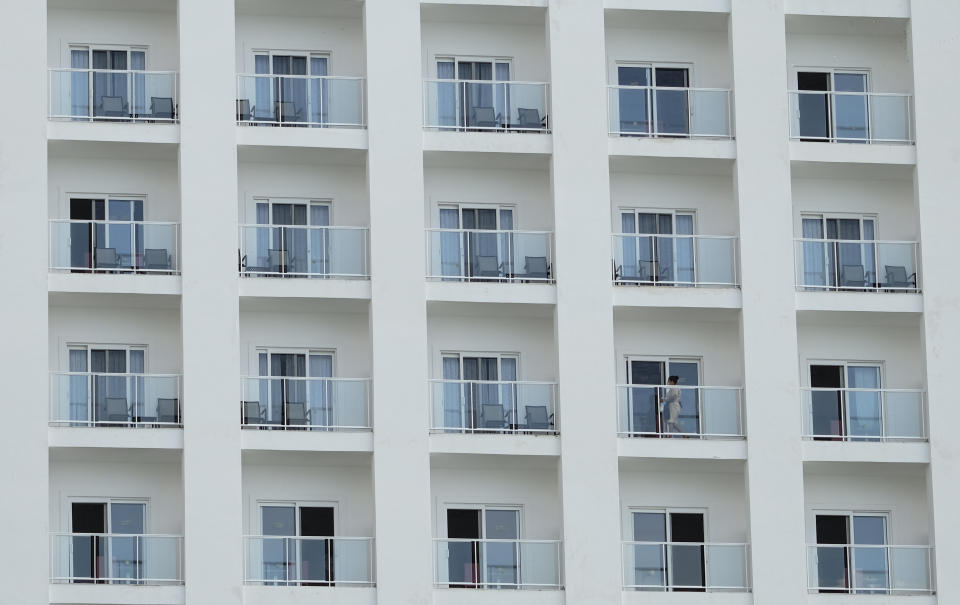 A member of a hotel's cleaning staff walks on a balcony in Cancun, Mexico, Saturday, June 13, 2020. Mexico's tourism income crashed amid the lockdown to curb the spread of the new coronavirus pandemic, and hundreds of thousands of hotel rooms were shut down, while tourism workers across all sectors were sent home to wait it out. (AP Photo/Victor Ruiz)