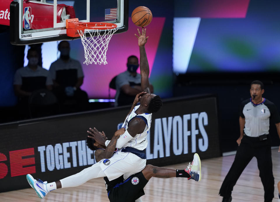 Los Angeles Clippers' Lou Williams (23) fouls Dallas Mavericks' Dorian Finney-Smith (10) during the first half of an NBA first round playoff game Sunday, Aug. 30, 2020, in Lake Buena Vista, Fla. (AP Photo/Ashley Landis)