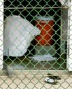 KRT WORLD NEWS STORY SLUGGED: GUANTANAMO-TRIBUNAL KRT POOL PHOTOGRAPH BY MARK WILSON/GETTY IMAGES (August 26) GUANTANAMO BAY, CUBA -- A detainee sits near a water cooler at Camp 4 inside of the maximum security prison Camp Delta at Guantanamo Naval Base in Guantanamo Bay, Cuba, on Wednesday, August 26, 2004. This week the U.S. Military held preliminary hearings for four detainee's charged with conspiracy to commit war crimes. (nk) 2004