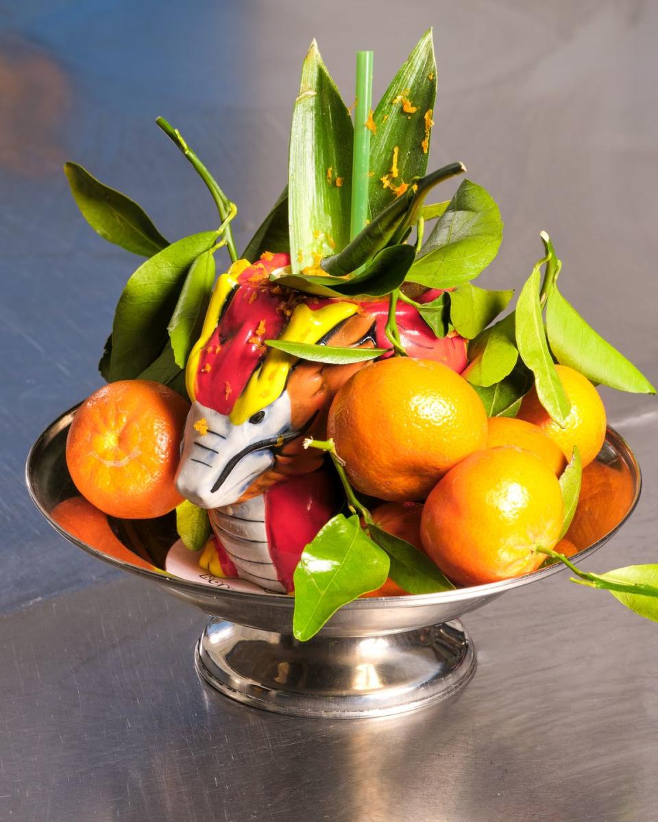 a bowl of oranges and a lemon