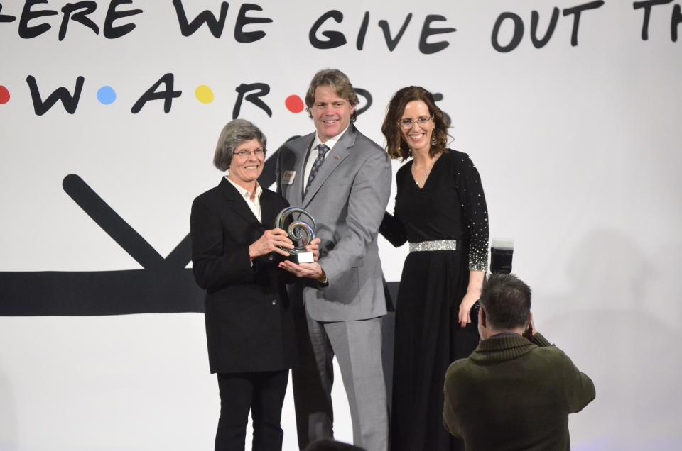 Lisa Burkhardt of the Richmond Rose Garden receives the award for Achievement in Excellence for a Nonprofit from 2024 Chamber Board Chair Ron Holbrook and Chamber President and CEO Melissa Vance during the 2024 Wayne County Area Chamber of Commerce Annual Dinner at First Bank Kuhlman Center, Friday, Jan. 19, 2024.