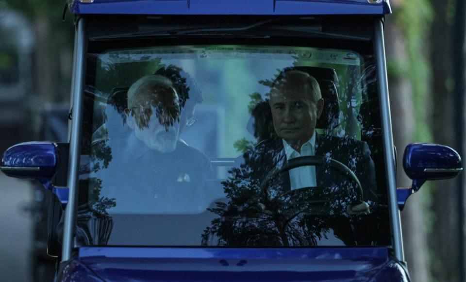 Vladimir Putin and Narendra Modi ride in a golf cart before their meeting in Moscow (EPA)