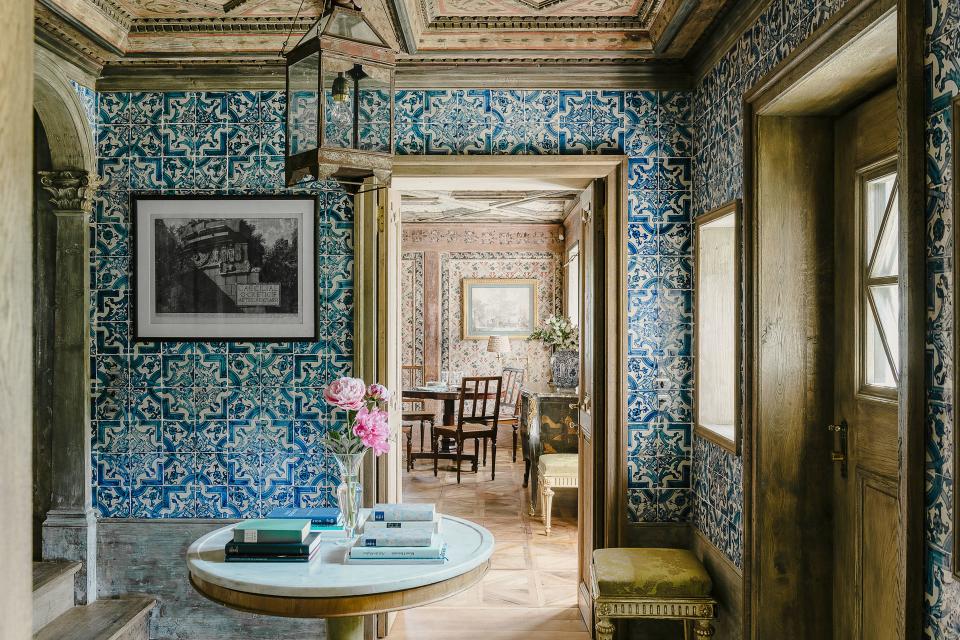 Blue-and-white Portuguese tiles from the 17th century cover the walls of the entry hall. Art by Giovanni Battista Piranesi; antique iron lantern.