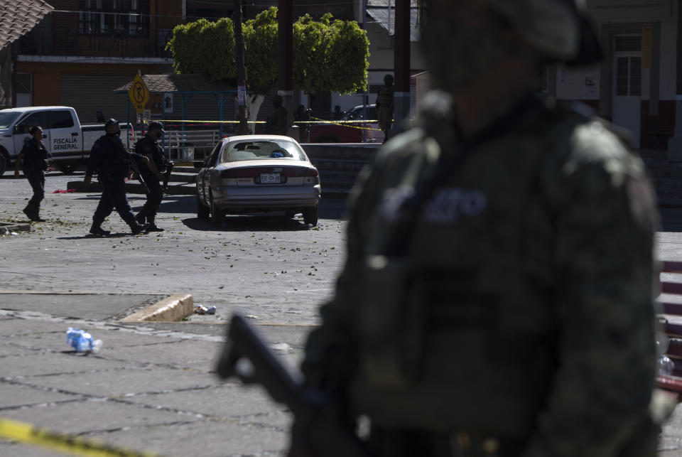 Police work the area of a massive shootout in Parangaricutiro, Mexico,Thursday, March 10, 2022. Authorities in the avocado-growing zone of western Mexico said five suspected drug cartel gunmen have been killed in a massive firefight between gangs. ( AP Photo/Armando Solis)