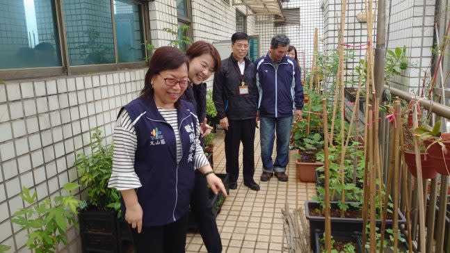 歐陽禾英（左一）引導台北市副市長黃珊珊（左二）和市府人員參觀梓新里社區菜圃。（圖片來源：樟新里辦公處提供）