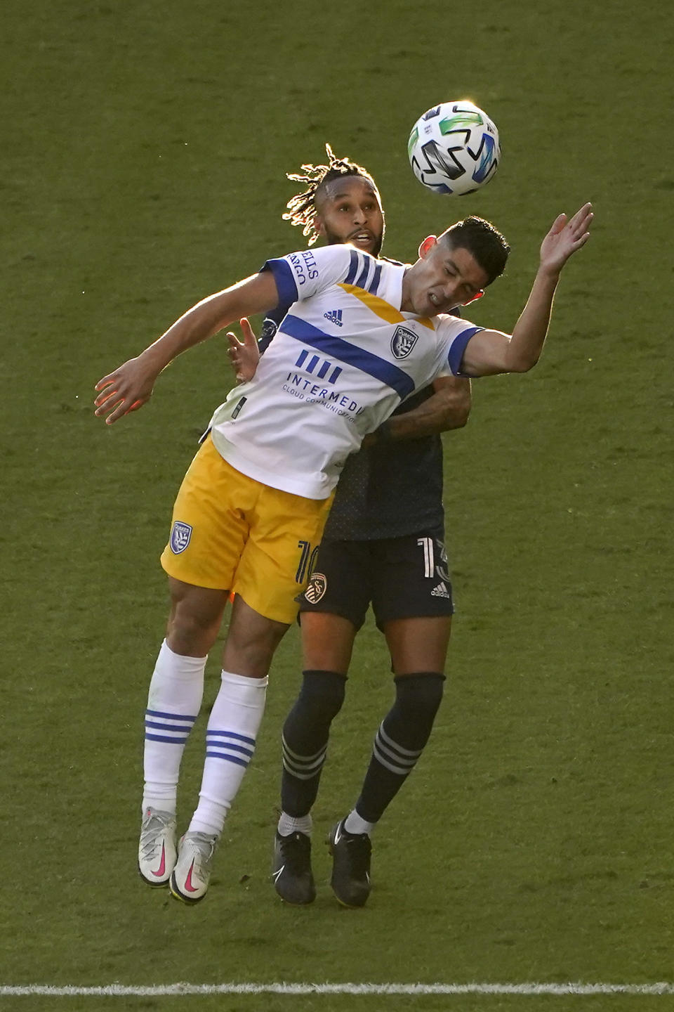 San Jose Earthquakes forward Cristian Espinoza (10) and Sporting Kansas City defender Amadou Dia (13) battle for the ball during the first half of an MLS soccer match Sunday, Nov. 22, 2020, in Kansas City, Kan. (AP Photo/Charlie Riedel)