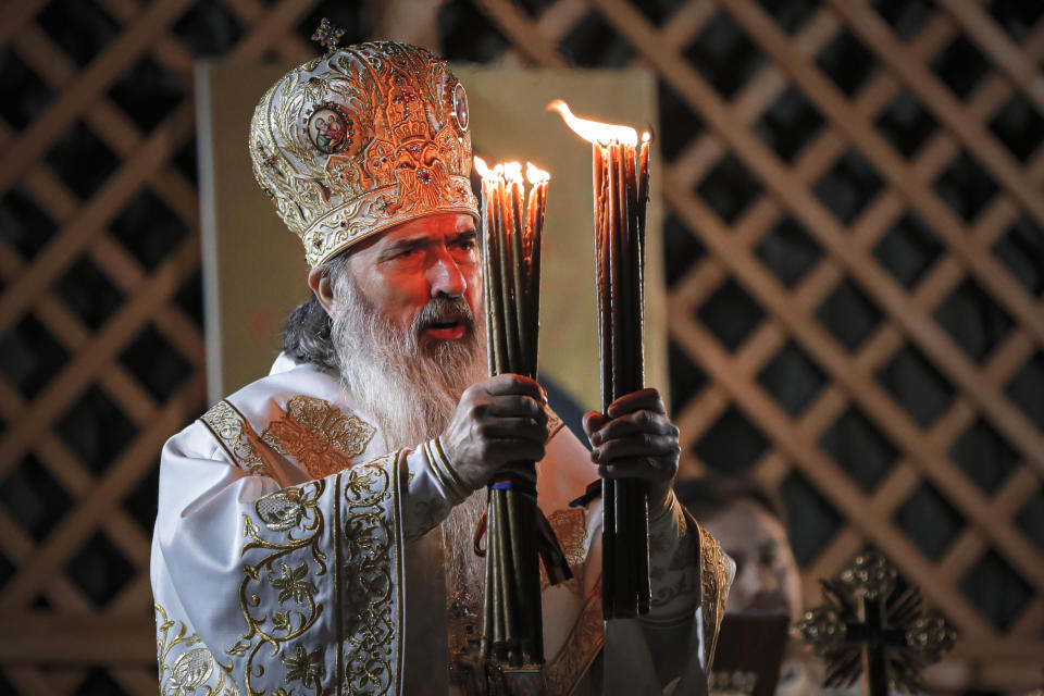 Orthodox Archbishop Teodosie prepares to distribute holy light during a religious service in the Black Sea port of Constanta, Romania, shortly before midnight on Tuesday, May 26, 2020. (AP Photo/Vadim Ghirda)