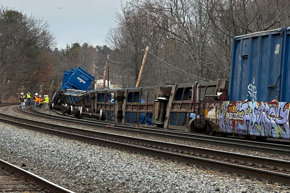 Officials work at the scene of a freight train derailment Thursday in Ayer.